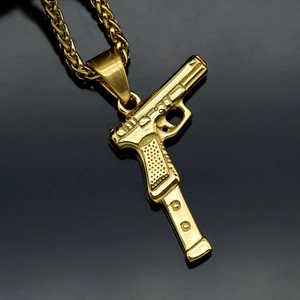 Minimalist gold plated pistol pendant necklace with twisted rope chain on mirror surface