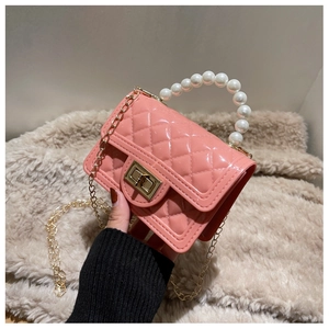 Detail of pink quilted jelly bag featuring pearl handle and golden chain strap