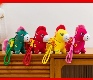 Vibrant 2026 Year of the Horse plush mascots in four colors displayed on a wooden surface.