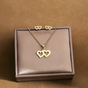 Close-up of golden interlocking heart necklace and earring set in a premium gift box