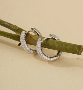 Macro detail of U-shaped S925 silver hoop earrings with micro-pave cubic zirconia stones
