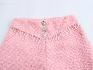 Detail der rosa Tweed-Shorts mit Kristallknöpfen und weißen Perlenfransen-Quasten