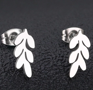 Macro shot of polished silver leaf-shaped stainless steel stud earrings on black background