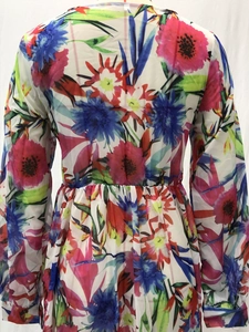 Détail d'une robe longue fleurie à manches longues avec taille élastique et motif vibrant