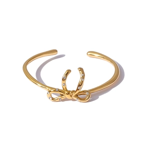 Bracelet jonc nœud élégant plaqué or 18K avec strass blancs sur fond blanc épuré