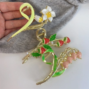 Detail of tulip and strawberry hair claws with enamel finish and pearl accents