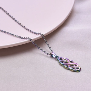Iridescent witch knot pendant necklace on soft silk background, detailed macro shot