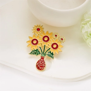 Detailed close-up of a sunflower vase brooch with yellow enamel petals and red rhinestones