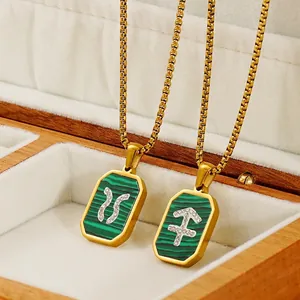 Colliers zodiaque en acier doré avec pendentifs malachite et cristaux dans une boîte à bijoux