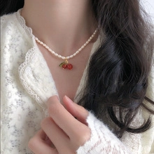 Dettaglio della collana di perle con ciondoli a ciliegia rossi e perle d'acqua dolce naturali