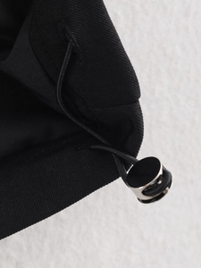 Detail of black fabric texture featuring a functional drawstring and silver metal cord lock