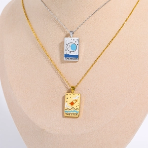 Close-up of tarot card necklaces featuring Moon and Star designs on mannequin