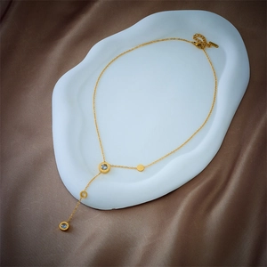 Golden Y-shaped tassel necklace with crystal circles and Roman numerals on silk