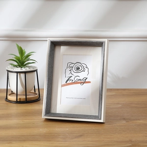Modern minimalist white and grey wood grain photo frame displayed on wooden table