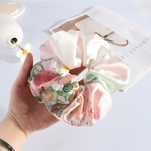 Detail of floral oil painting print satin scrunchie with soft silk texture and glossy finish