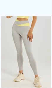Detalle de la cintura alta asimétrica amarilla en contraste de los leggings de yoga gris