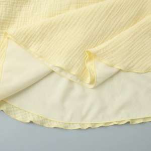 Detail of yellow cotton dress showing the hem texture and smooth inner lining