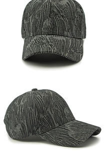 Detail view of a dark grey baseball cap featuring palm leaf jacquard textured fabric