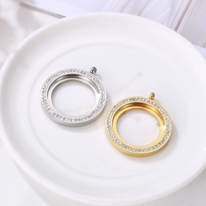 Silver and gold round locket pendants with zircon edges on white ceramic tray