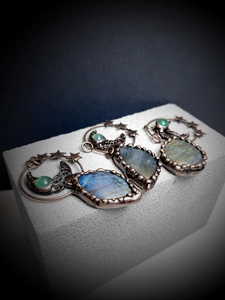 Detailed view of handmade vintage labradorite pendants with moon and star metalwork