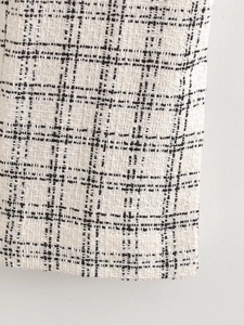 Detail shot of black and white tweed fabric texture with classic checkered pattern