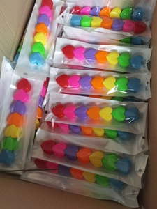 Detail of colorful heart-shaped stacking pens in bulk packaging for creative stationery