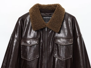 Close-up of brown faux leather jacket with plush shearling collar and metallic zipper
