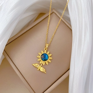 Détail du collier tournesol avec pierre bleue étoilée dans son écrin à bijoux