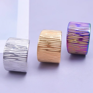 Three wide band rings in gold, silver, and rainbow colors with a realistic bark texture finish