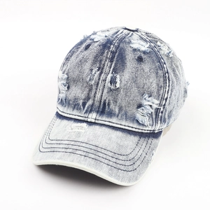 Close-up of distressed vintage washed denim baseball cap with worn holes and stitching