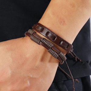 Close-up of brown braided leather bracelets featuring multilayer cords and adjustable ties