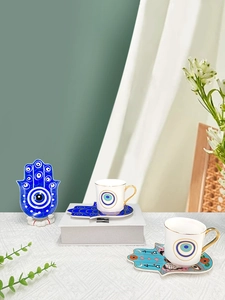 Dettaglio del vassoio Hamsa in ceramica e tazzina Evil Eye con elegante manico dorato