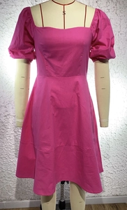 Detail of rose pink square neck dress with puff sleeves and textured cotton fabric