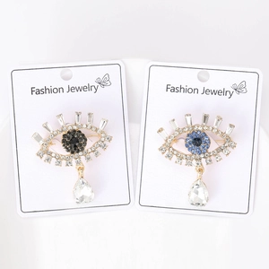 Detail view of Evil Eye brooches with blue and black crystals on display cards