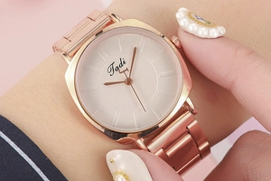 Gros plan d'une montre à quartz coussin en or rose avec bracelet en métal élégant