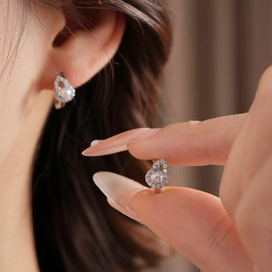 Close-up of heart-shaped pearl earrings with cubic zirconia in a modern Chinese style