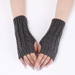 Detailed close-up of dark grey cable knit fingerless gloves showing warm textured wrist warmers