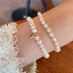 Detail of baroque freshwater pearl bracelets with 14K gold-filled bead on female wrist