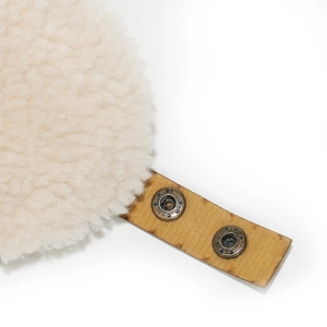 Detail of plush lamb wool fabric and leather strap with vintage bronze star buckles