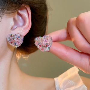 Detailed view of pink heart earrings featuring colorful beads worn by a model