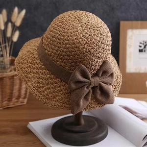 Detail of hand-woven straw hat with elegant dark brown ribbon and a large bow decor