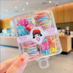 Close-up of colorful star hair clips and spiral elastics in a cute transparent gift box