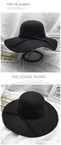 Detail of a black wide-brimmed felt wool hat with a decorative ribbon bow accent