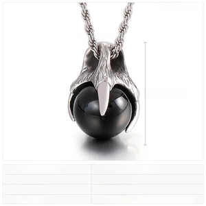 Macro shot of punk dragon claw pendant in stainless steel with a black glass sphere