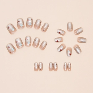 Flat lay of 24 cute press-on nails featuring pink gradient, stars and red bow patterns