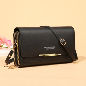 Elegant black pebbled leather crossbody long wallet with gold zippers on beige background
