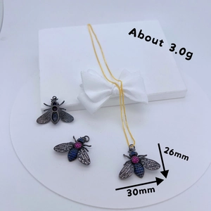 Detailed view of bee jewelry set with blue and pink crystals on a white display box