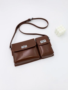 Detail of dark brown baguette bag with double flap pockets and silver twist locks