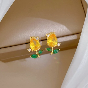 Detail of tulip flower earrings with yellow pear-cut stones and green leaf gems