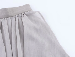Detailed macro view of taupe pleated chiffon waist design with elastic texture